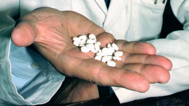 The inventor of the RU-486 abortion pill, French Professor Emile-Etienne Baulieu, holds some pills in this 1995 file photo.