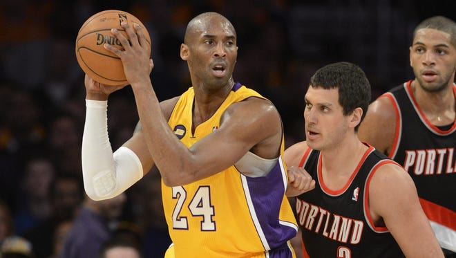Los Angeles Lakers shooting guard Kobe Bryant looks to pass against Portland Trail Blazers shooting guard Sasha Pavlovic.