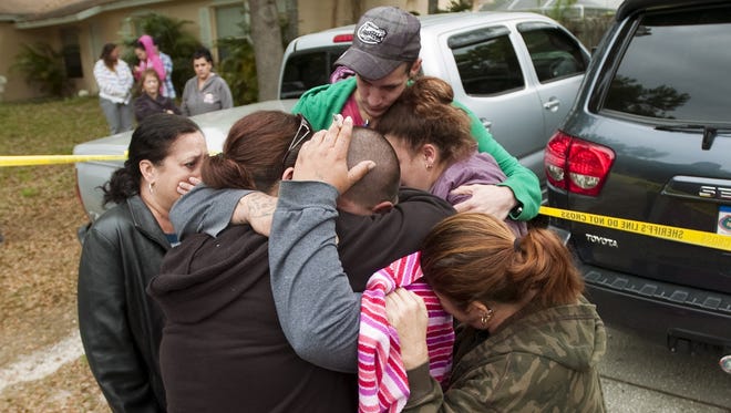 Jeremy Bush, center with hand on head, is embraced by family and friends Friday outside his home on Faithway Drive in Seffner, Fla.