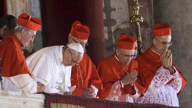 Pope Francis and cardinals pray from the central balcony of St. Peter's Basilica at the Vatican on Wednesday.