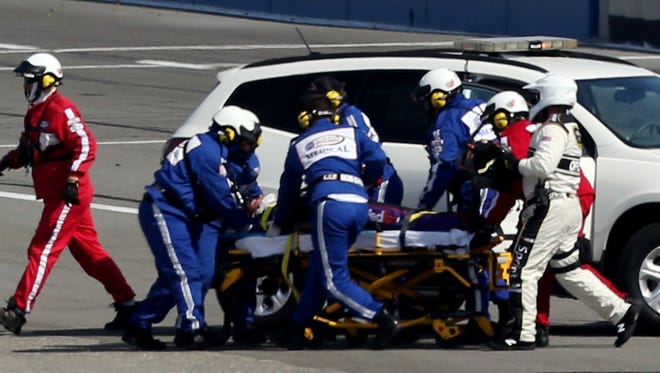 Safety workers attended to Denny Hamlin, after an incident with Joey Logano  on the final lap during the NASCAR Sprint Cup Series Auto Club 400 Sunday in Fontana, Calif. Hamline will be out six weeks with a fracture in his back.