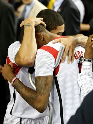 Louisville's Peyton Siva hugs his injured teammate Kevin Ware after Louisville's win over Wichita State in semi fina in NCAA Final Four.