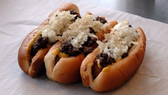Olneyville N.Y. System, North Providence, R.I.: NY System Dog; The New York System dog is a regional specialty: small franks (in this case, from Little Rhody) are steamed, placed atop a steamed bun, and topped with a cumin-heavy meat sauce, yellow mustard, diced onions, and celery salt. You're going to want to order a few of these, because they're small and addictive (see how many of them the counterman can balance on his arm). The "wiener sauce" is so popular that people have been requesting the recipe for years; you can purchase a packet of seasoning online and make it yourself at home.
