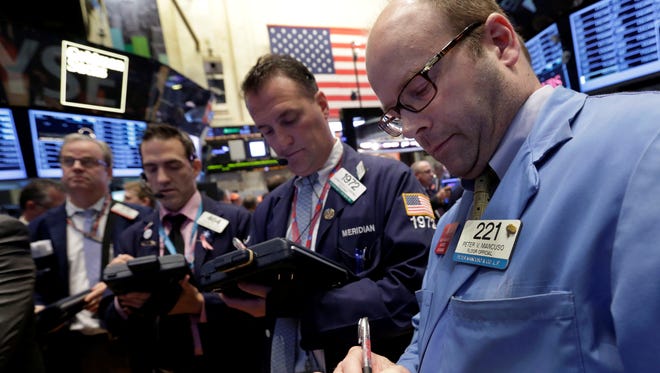 Peter Mancuso, right, works with fellow traders on the floor of the New York Stock Exchange.