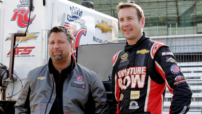 Andretti Autosport team owner Michael Andretti, left, and NASCAR driver Kurt Busch wait for the start of an IndyCar testing session Thursday at Indianapolis Motor Speedway.