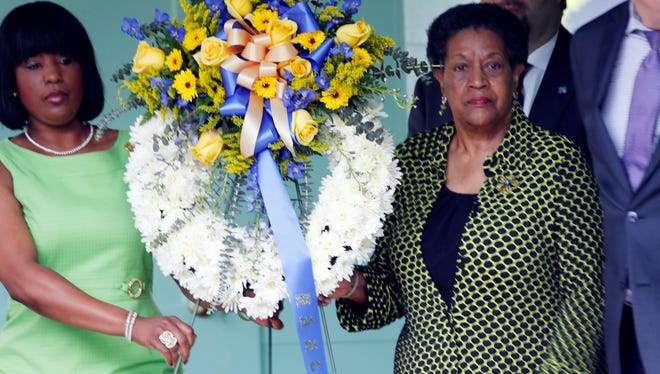 Myrlie Evers-Williams, widow of Medgar Evers, right, and Roslyn Brock, chairwoman of the NAACP national board of directors, carry a wreath to be placed in front of the former home of the slain civil rights leader on Thursday.