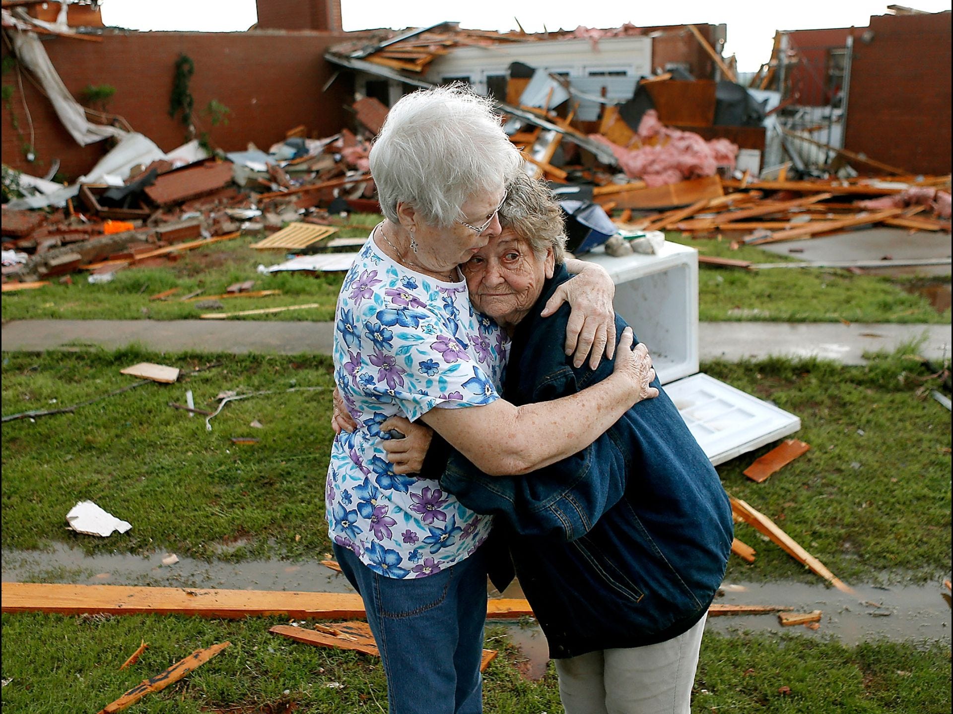 Earlene Langley, left, hugs from her friend Jerry Dirks after a tornado hit Dirks' home on May 19 near Carney, Okla. Dirks was in the cellar when the tornado struck.