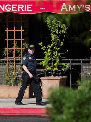 A private security guard patrols outside Amy's Baking Co. in Scottsdale, Ariz., before the grand reopening Tuesday, May 21, 2013.