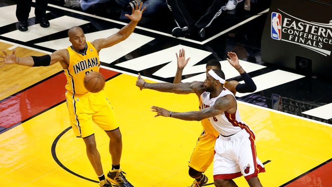 Pacers forward David West reaches to bat away a pass by Heat forward LeBron James during Game 2 of the Eastern Conference finals.