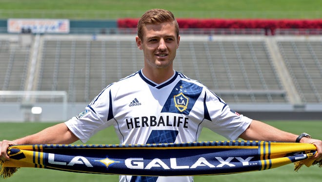 L.A. Galaxy midfielder Robbie Rogers poses for a photo with a scarf on the field after a he was introduced to the media during a press conference at The Home Depot Center.