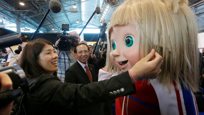 Japanese wrestler Saori Yoshid (left) and Tomiaki Fukuda, President of Japan Wrestling Federation (center) look at a Masha mascot of 2013 Combat Games at the SportAccord International Convention in St.Petersburg, Russia, Wednesday.