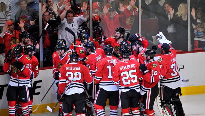 Chicago Blackhawks teammates mob defenseman Brent Seabrook after his overtime goal in Game 7.