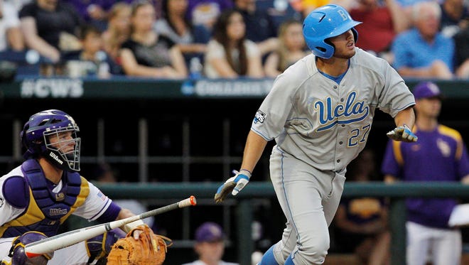 UCLA Bruins batter Pat Gallagher (27) gets a base hit against the LSU Tigers catcher Ty Ross (26) during the College World Series at TD Ameritrade Park.