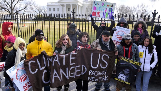 Climate change activists at the White House in February. President Obama is set to address it Tuesday.