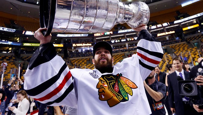Chicago Blackhawks goalie Corey Crawford hoists the Stanley Cup after defeating Boston Bruins at TD Garden.