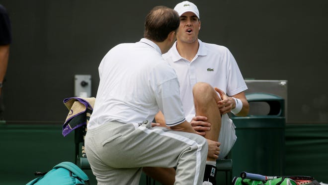 The USA's John Isner is attended to before retiring from his second round match.