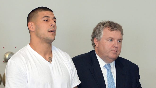 Former New England Patriots tight end Aaron Hernandez (left) stands with his attorney Michael Fee as he was arraigned Wednesday on charges of murder.