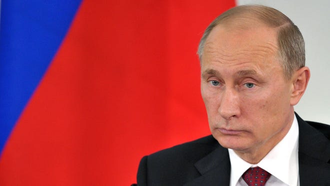 Russia's President Vladimir Putin, shown attending a meeting in the Belgorod region,  is quoted by RT.com as saying that NSA leaker Edward Snowden will leave Russia at the earliest opportunity.