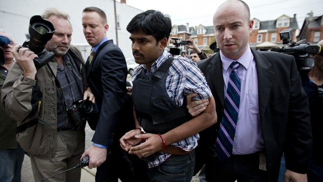 Raghunandan Yandamuri is escorted to a Montgomery County district court for an arraignment Oct. 26, in Bridgeport, Pa.  Investigators said Yandamuri killed 10-month-old Saanvi Venna and her grandmother Satyavathi Venna.