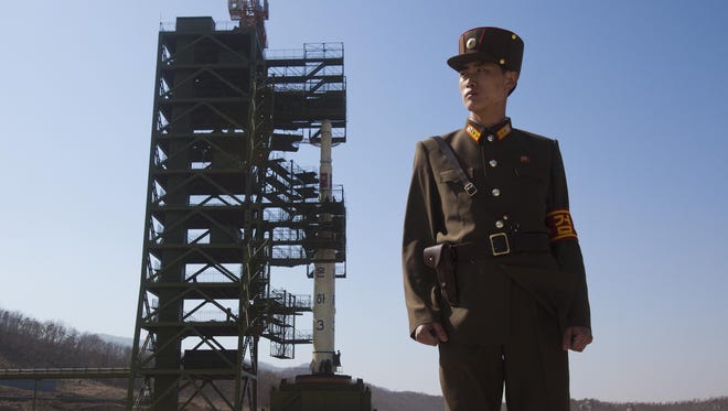 A North Korean soldier stands in front of the country's Unha-3 rocket, which was slated for liftoff between April 12-16, 2012.