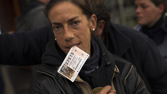 A woman bites a ticket of the famed Christmas lottery, billed as the world's richest, in Madrid on Friday.