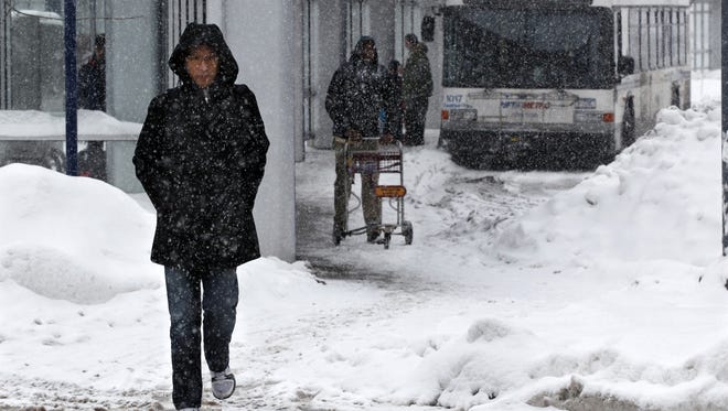 People walk in the snow in Buffalo, N.Y., Saturday.