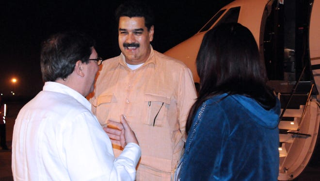 In this photo provided by Cuba's state newspaper Granma, Cuban Foreign Minister Bruno Rodriguez , left, talks with Venezuela's Vice President Nicolas Maduro, center, as Venezuelan Attorney General Cilia Flores watches at the Jose Marti International Airport in Havana on Saturday.