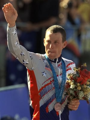 Lance Armstrong waves after receiving the bronze medal in the men's individual time trials at the 2000 Summer Olympics in Sydney.
