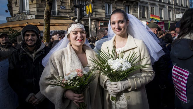Women pose during a demonstration for the government project to legalize same-sex marriage and adoption for same-sex couples in Paris, France, Sunday, Jan. 27, 2013.