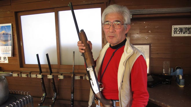 In this Friday, Jan. 18, 2013 photo, Japanese rifle enthusiast Yasuharu Watabe displays his gun at a shooting range in Ooi, near the foot of Mount Fuji.