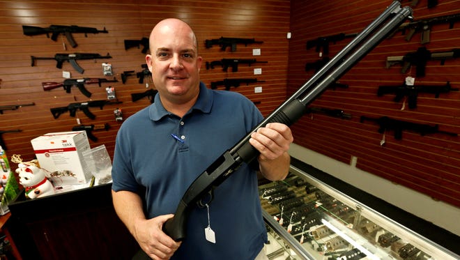 Former Tucson, Ariz. mayoral candidate Shaun McClusky poses with a shotgun at Black Weapons Armory in Tucson, Thursday.