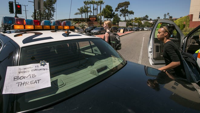 A sign is posted on a police car to inform students of a bomb threat the Cal State University Los Angeles campus, after a mandatory evacuation on a report of a suspicious item, according to the Los Angeles Police Department in Los Angeles Thursday.