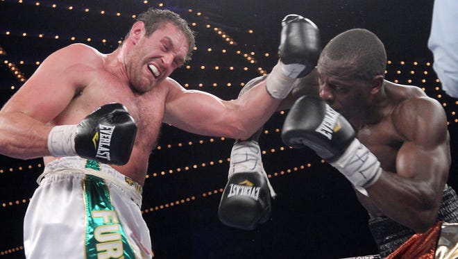 Tyson Fury, left, lands an uppercut on Steve Cunningham during a heavyweight boxing match Saturday at the Theatre at Madison Square Garden. Fury knocked out Cunningham in the seventh round.