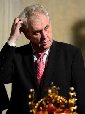 FILE-In this May 9, 2013 file photo, Czech President Milos Zeman scratches his head during a ceremonial movement of the Czech Crown Jewels  for a rare showing to the public from the Crown Jewels chamber in the St. Vitus Cathedral to the Vladislav Hall at the Prague Castle. The Crown of Saint Wenceslas is seen in front.  Was he or wasn't he? The video footage shows the new Czech president clearly worse for wear, propping himself up against a wall at a public event, struggling to negotiate a step and being aided by a cardinal.  Milos Zeman makes no secret of his drinking. But on this occasion _ a rare and highly-ceremonial public display of the Czech crown jewels last week _ his office insisted he simply had a virus and subsequently needed a day or two of rest.  (AP Photo/CTK, Michal Kamaryt) SLOVAKIA OUT