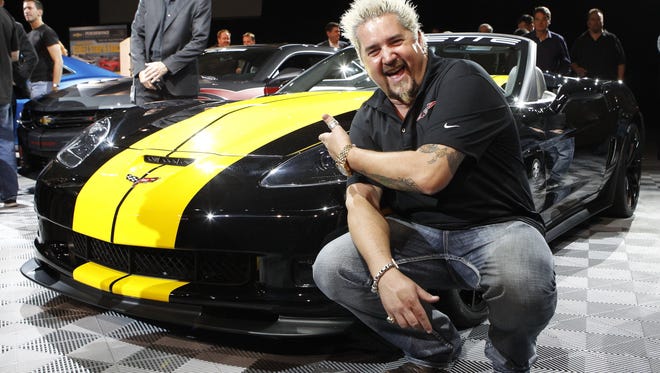 Guy Fieri, host of Diners, Drive Ins, and Dives, shows off his "cooked up" Chevrolet Corvette C6 special edition during the Chevrolet Media Reception at the SEMA convention in Las Vegas