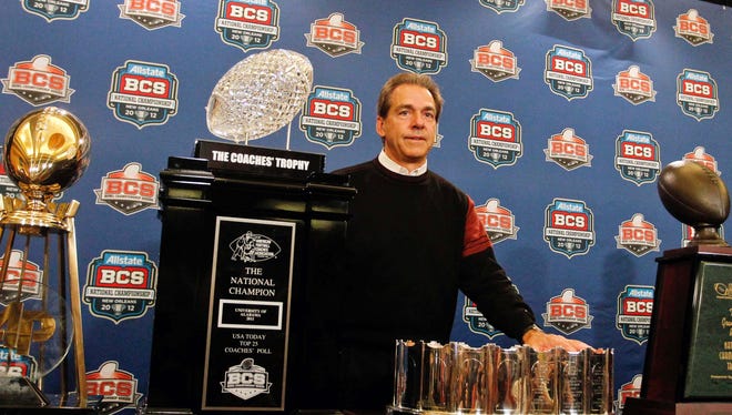 Alabama coach Nick Saban posing with the national championship trophy after January's win over LSU.
