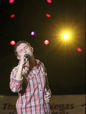 This March 30, 2012, file photo shows Scotty McCreery performing at a concert hosted by The Academy of Country Music at the ACM Fremont Street Experience in Las Vegas. The platinum-selling teen and former "American Idol" champ began his freshman year at North Carolina State University recently and he's managed to work out a schedule that allows him to balance his college education with his country music education.