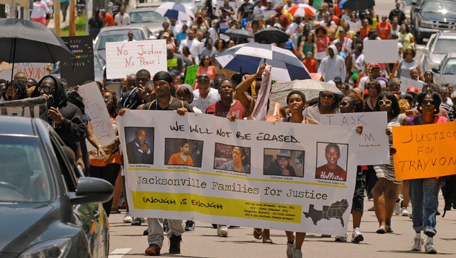 Protesters make their way down East Duval Street on the final leg of their march in Jacksonville on July 20. Several hundred protesters gathered to express a variety of grievances, including the verdict in the George Zimmerman trial and the sentence received by Marissa Alexander. Alexander is pictured in the center of the protest banner.