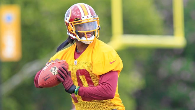Washington Redskins quarterback Robert Griffin III (10) prepares to throw the ball during opening day of 2013 NFL training camp at the Bon Secours Washington Redskins Training Center.