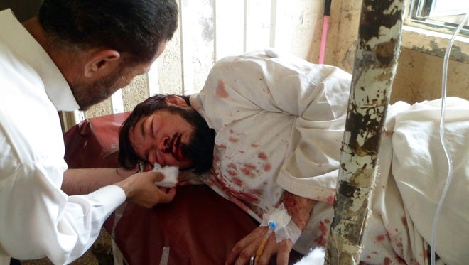 A Pakistani paramedic treats an injured blast victim at a hospital in Parachinar, the main town of Kurram tribal district on July 26, following twin bomb explosions.