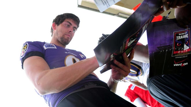 Ravens kicker Justin Tucker signs autographs for fans after training camp at the Under Armour Performance Center.
