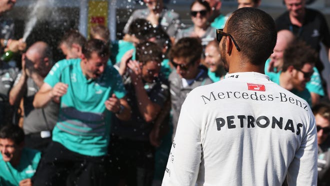 Lewis Hamilton celebrates with teammates after his first win of the season.
