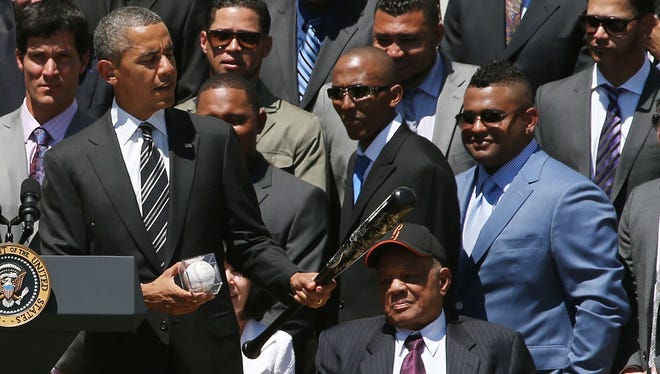 President Barack Obama is presented with a bat and ball from the Giants.