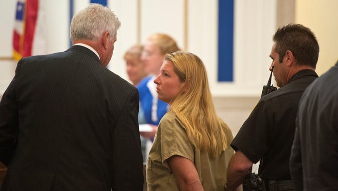 An officer leads teacher Julie Hautzenroeder of Colerain High School is led out of the courtroom July 31, 2013, after her bail was set. The 36-year-old was arrested Tuesday for having sex with two students.