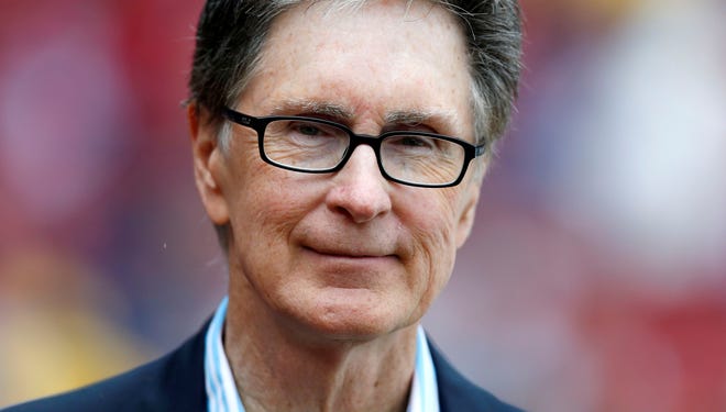 Boston Red Sox owner John Henry stands on the field before a baseball game in Boston, May 11, 2013.