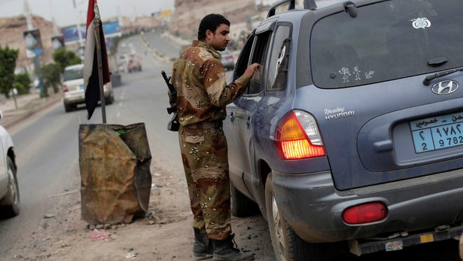 A Yemeni soldier inspects a car at a checkpoint on a street leading to the U.S. Embassy in Sanaa on Aug. 4.