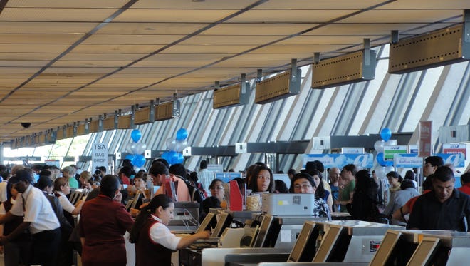 Airline passengers line up at the ticket counters to check-in for their flights at Washington Dulles International Airport on July 26, 2011.