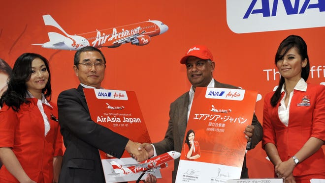 This July 21, 2011, photo shows ANA president Shinichiro Ito (second from left) shaking hands with the CEO of Asia's largest budget carrier AirAsia, Tony Fernandes as they announce a low-cost joint venture.
