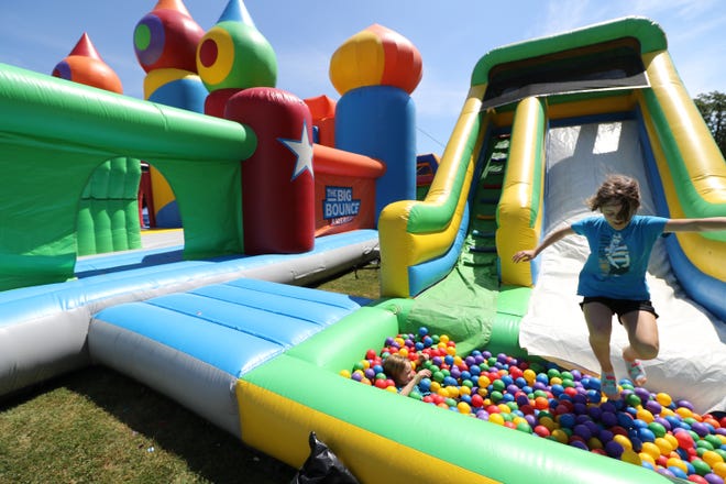 Alex Schwabe lands in a ball pit at the base of a slide attached to Big Bounce America that has inflated at Greenfield Park off Lincoln Avenue in West Allis for a three-day run beginning July 20. The main structure is 10,000 square feet of inflatable fun with a separate Bounce Village with a giant slide, basketball court, giant ball pit and an obstacle course. Tickets can be purchased for different one-hour sessions by age group - adults, too - online at www.thebigbounceamerica.com.