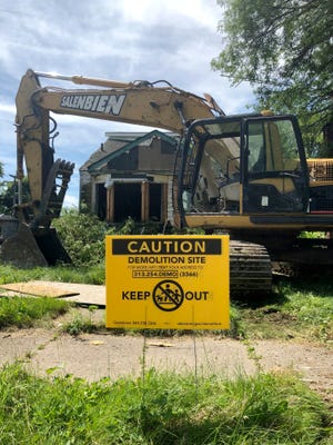 Demolition equipment sits outside a vacant house on Detroit's east side, Wednesday, July 18, 2018.
